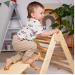 Il triangolo di Pikler aiuta il bambino a scoprire e sviluppare in modo sicuro i propri limiti motori.