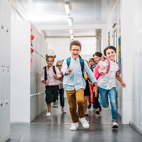 bambini corrono nel corridoio della scuola