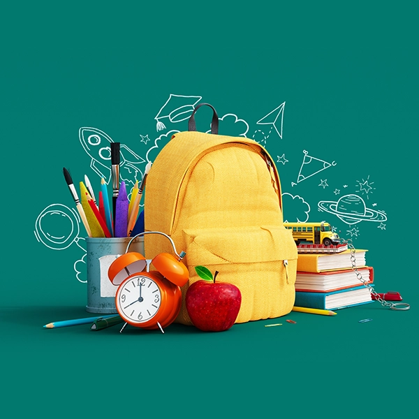 zaino giallo su sfondo verde con materiale scolastico