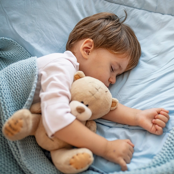 bambino che dorme serenamente nel letto