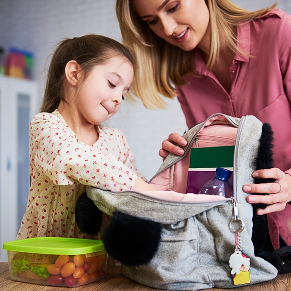 mamma e figlia preparano la merenda nello zaino