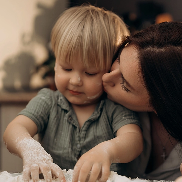 Una mamma bacia il proprio bambino durante un'attività tranquilla